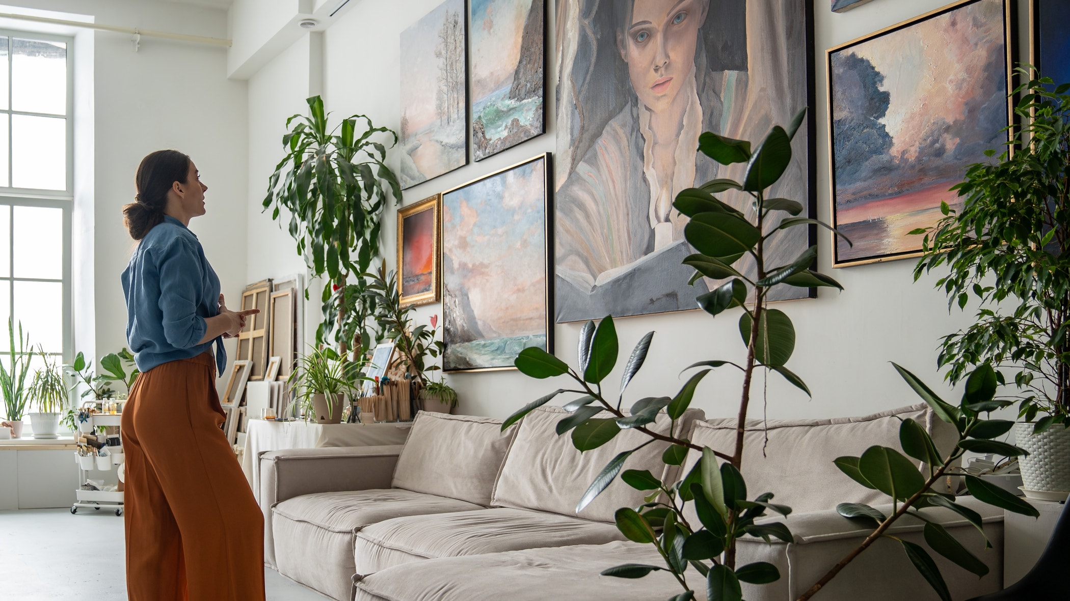 Creative workshop space with diverse collection of paintings, woman painter inspiration and new ideas for work.