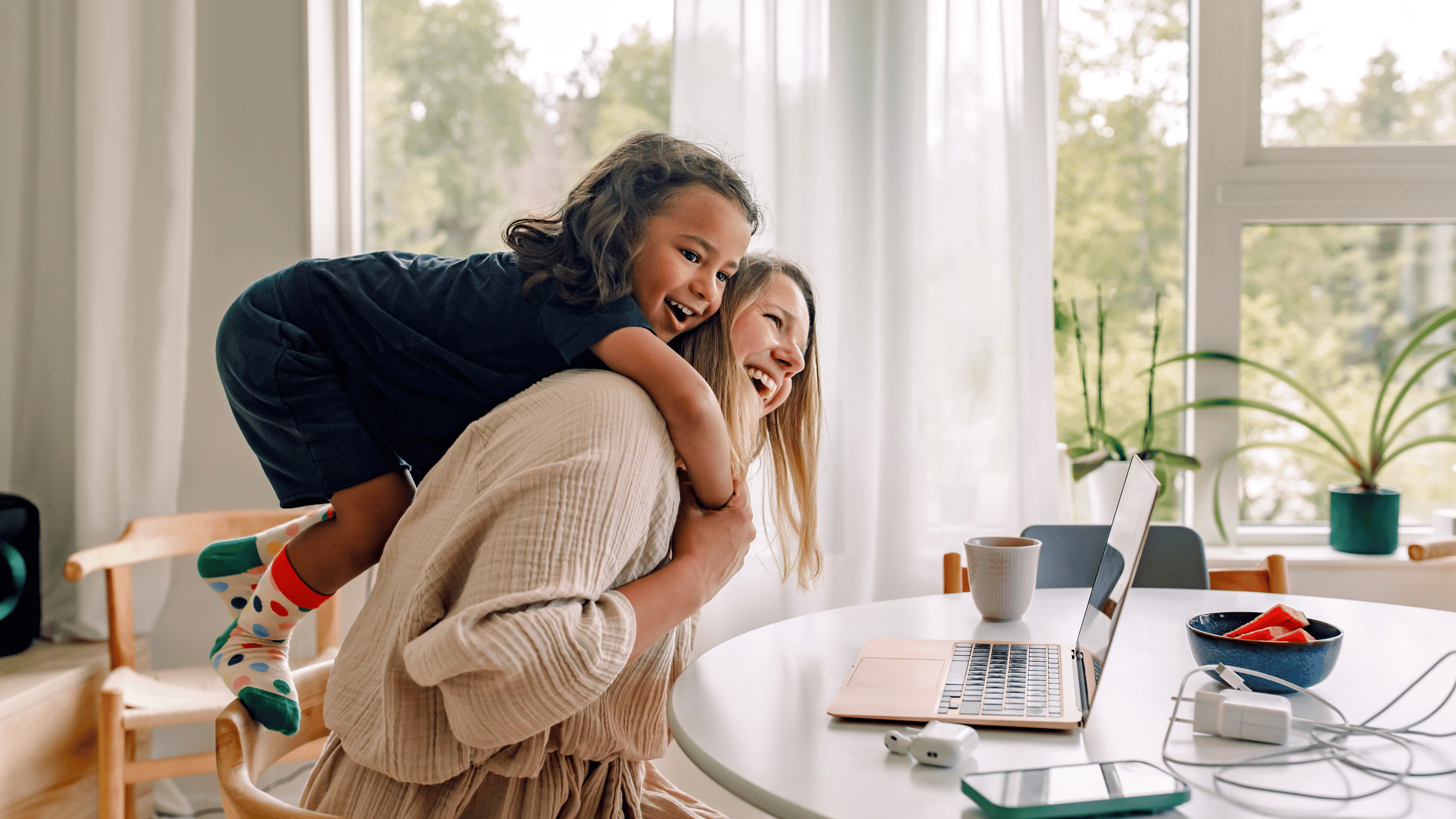 Happy mature mother carrying son on shoulders while sitting on chair near table at home.