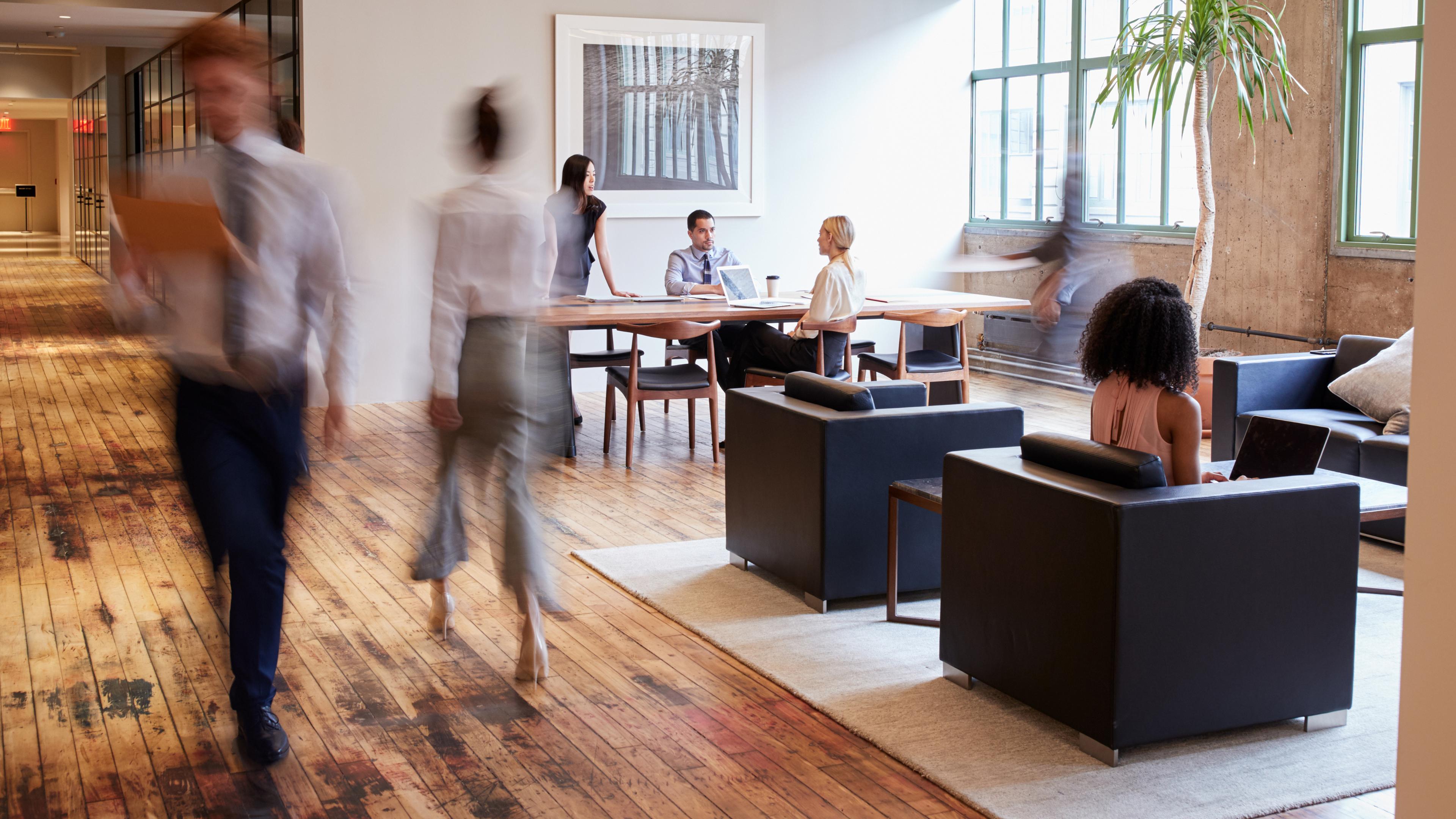 Business people at work in a busy luxury office space.