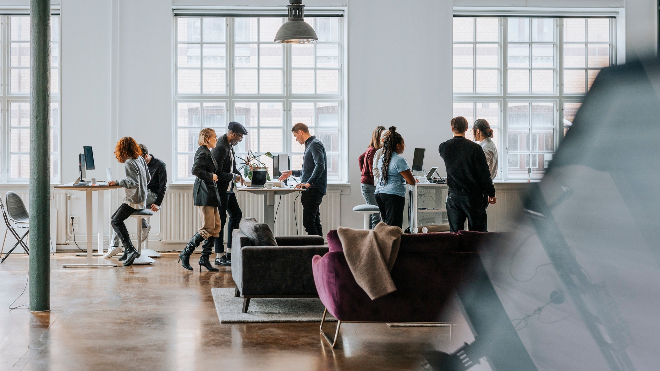 Professionals in a diverse group collaborate in a boardroom, engaging in a lively brainstorming session.