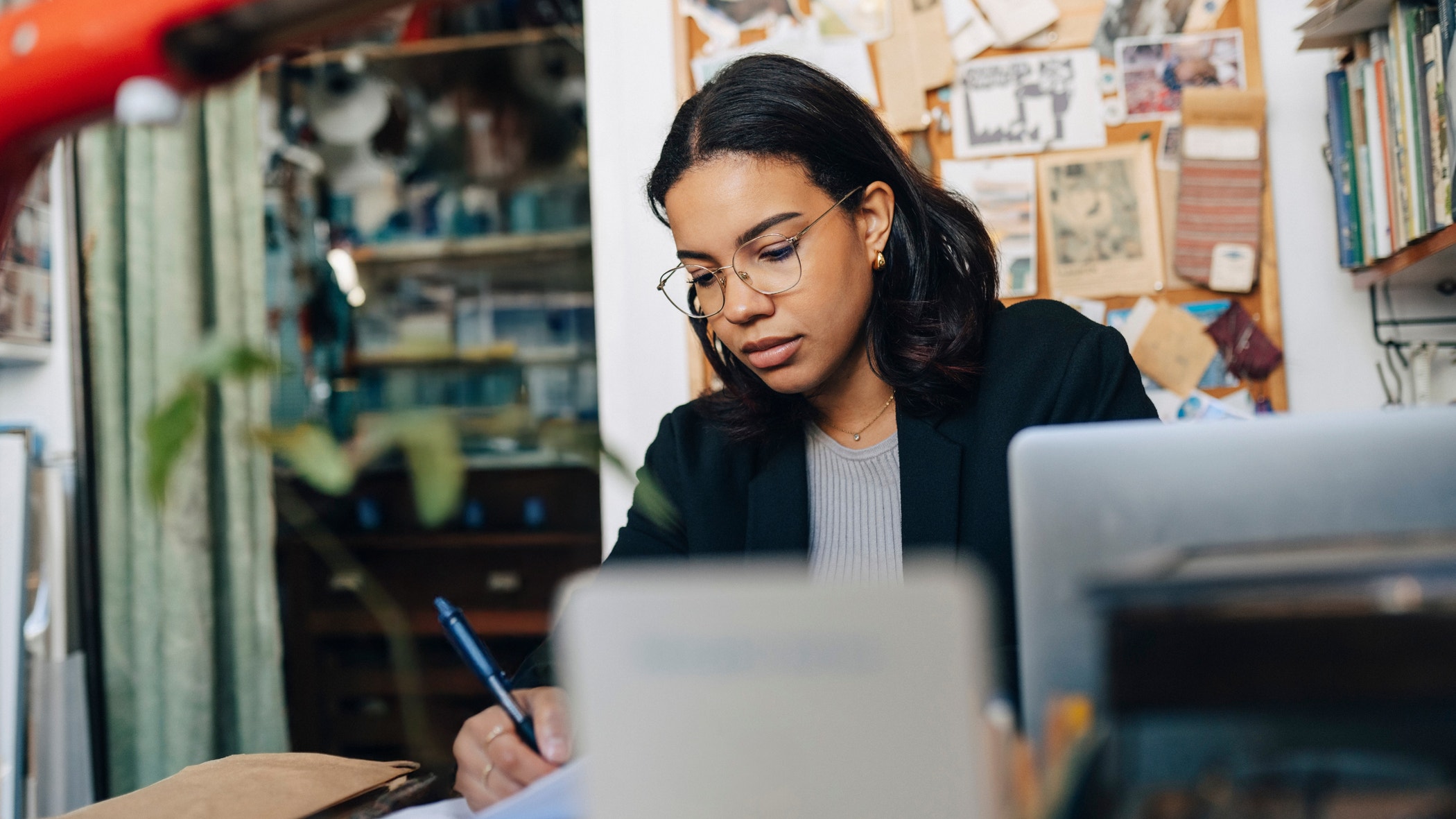 Female store owner wearing eyeglasses and working at antique store.