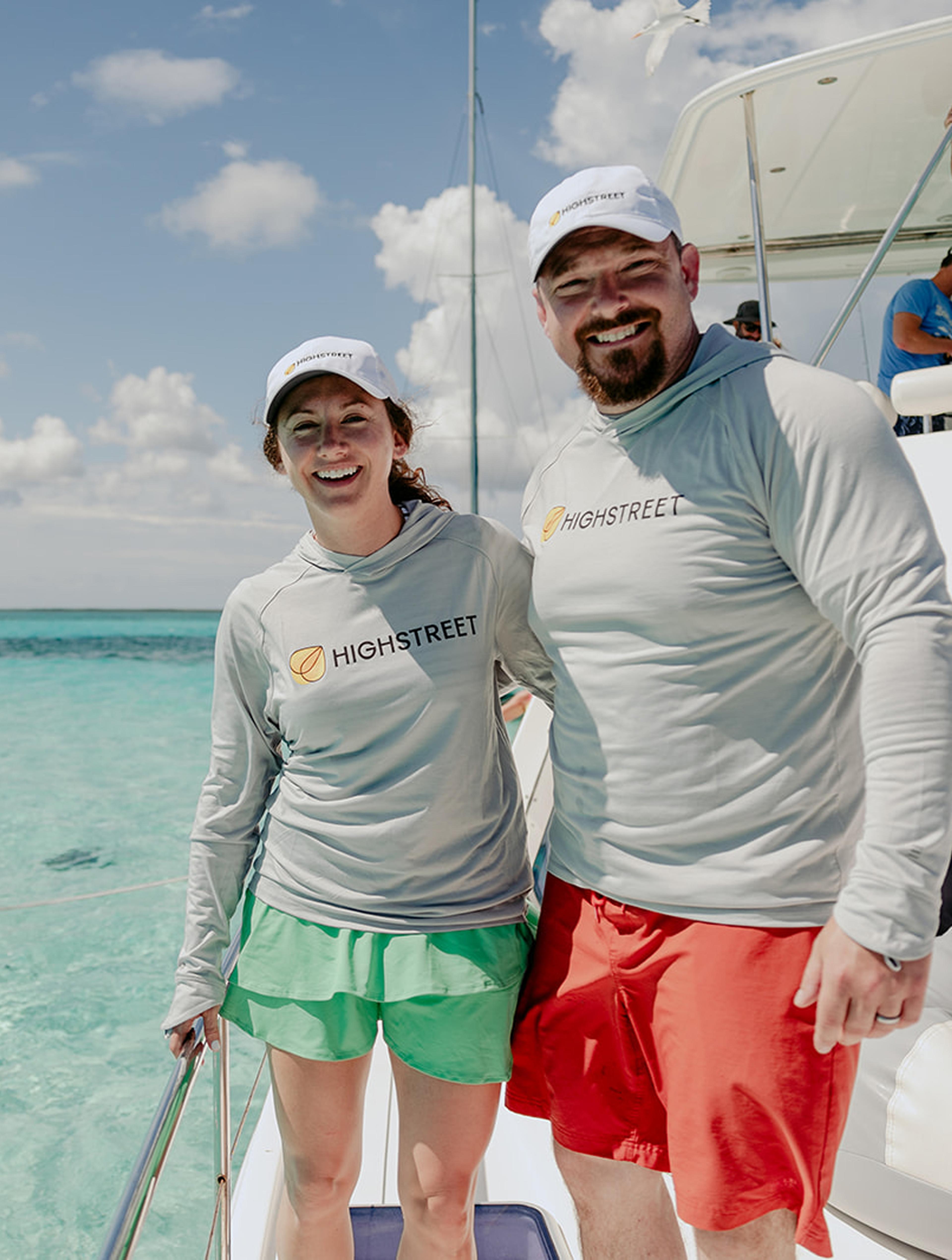 Two people on fishing boat wearing sweatshirts.