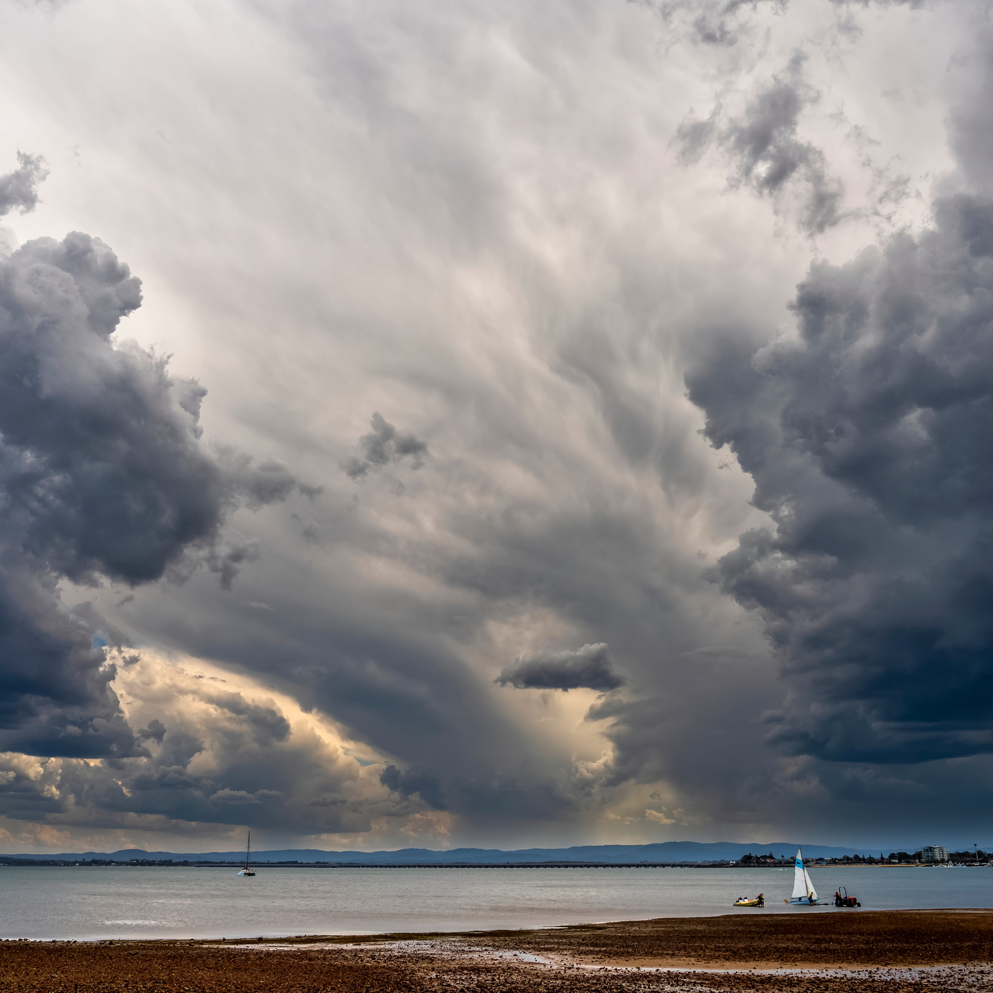 Storm clouds over a beach along the sunshine coast and the calm waters of the coral sea- queensland, australia