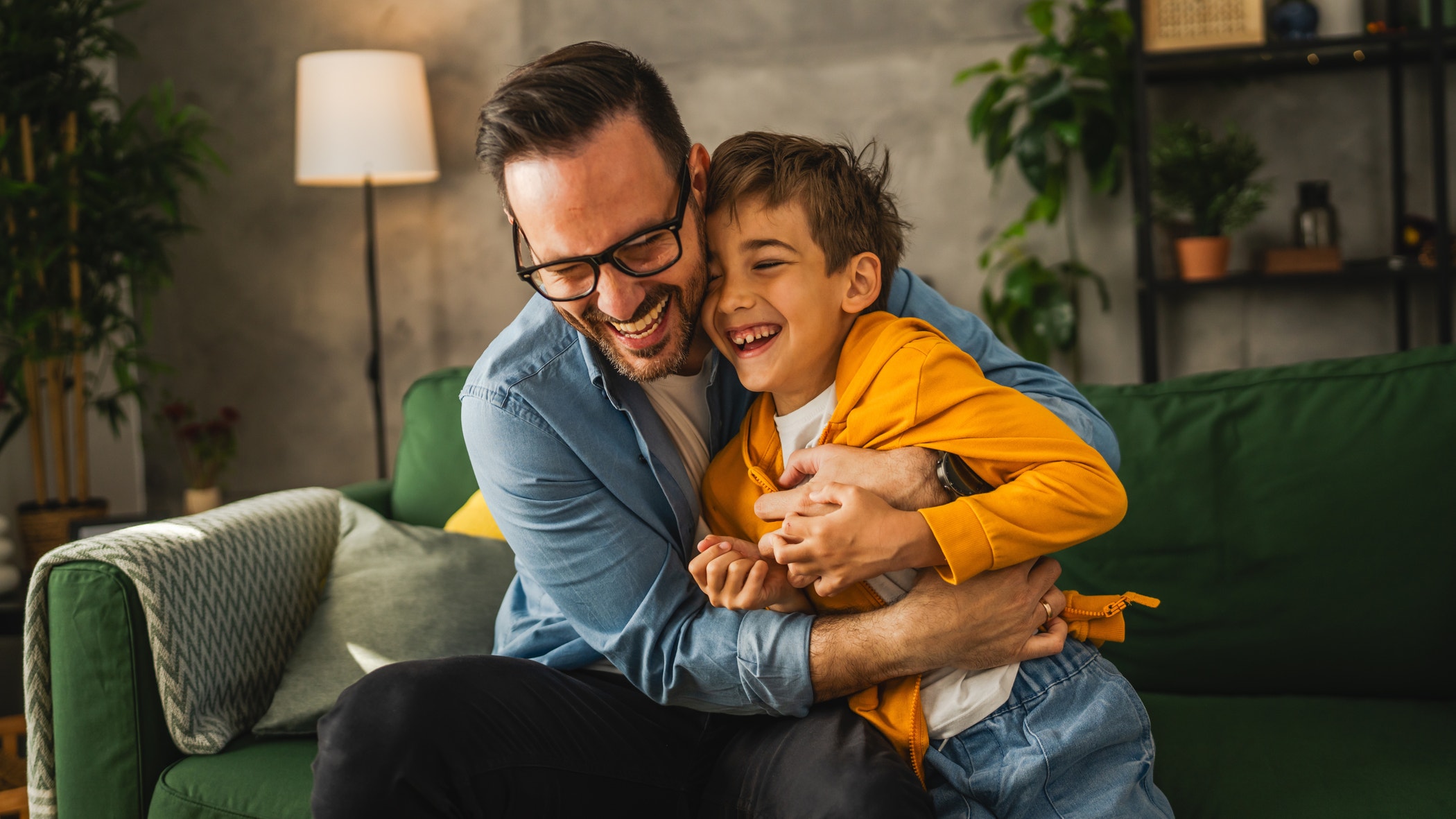 Dad and son caucasian tickle and have fun at home bonding happy together