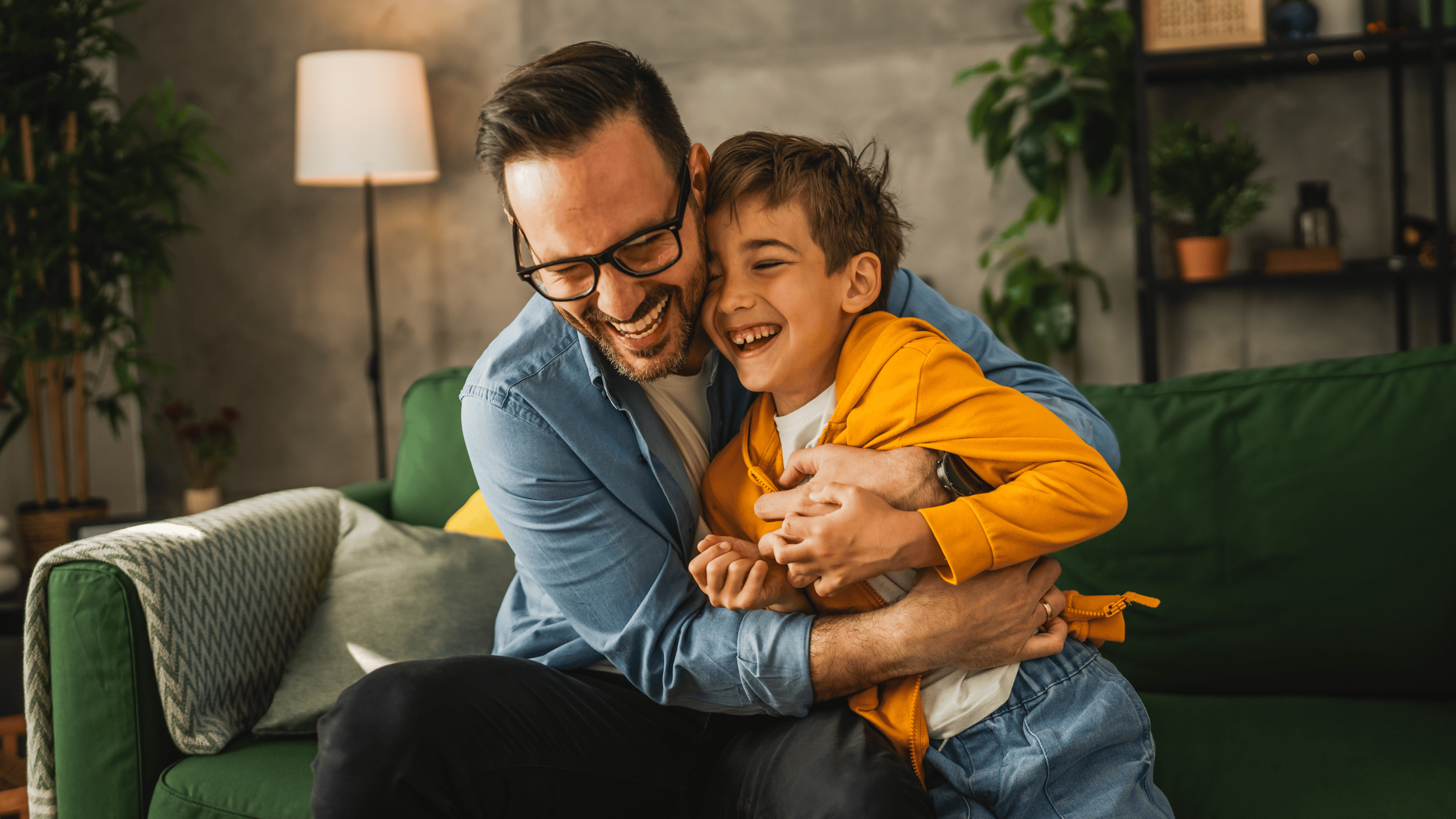 Dad and son caucasian tickle and have fun at home bonding happy together