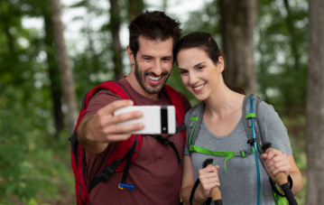 Two hikers taking a selfie with a smartphone