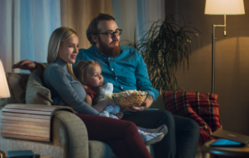 A family watching TV with popcorn