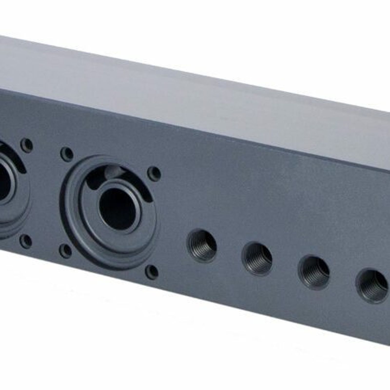 A black rectangular, PVC plastic hydraulic manifold block with multiple circular ports and threaded holes on its front and side surfaces, used for directing fluid flow in hydraulic systems.