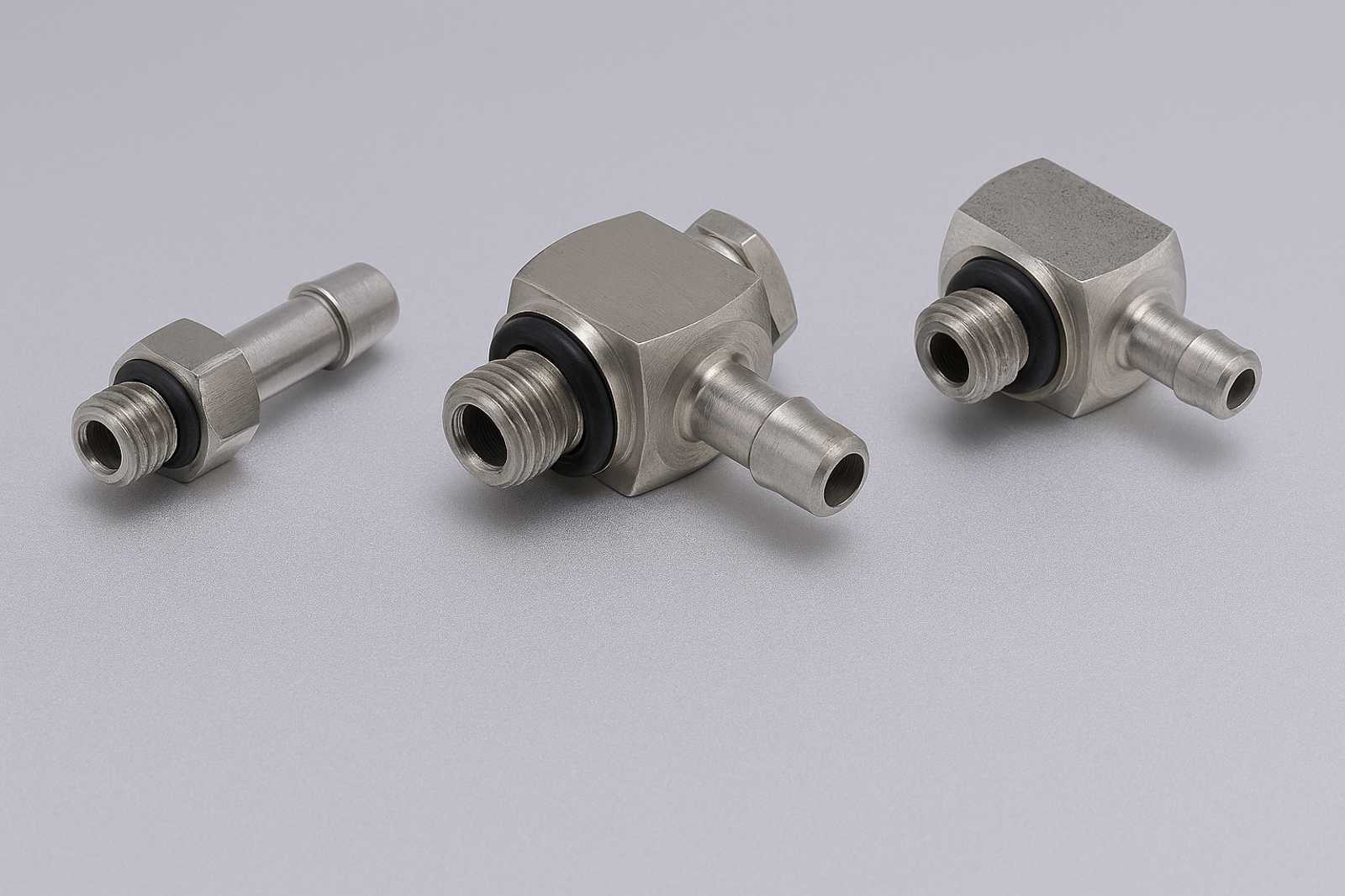 Close-up of a stainless steel barbed fitting with threaded end, used for secure tubing connections in fluidic assemblies.