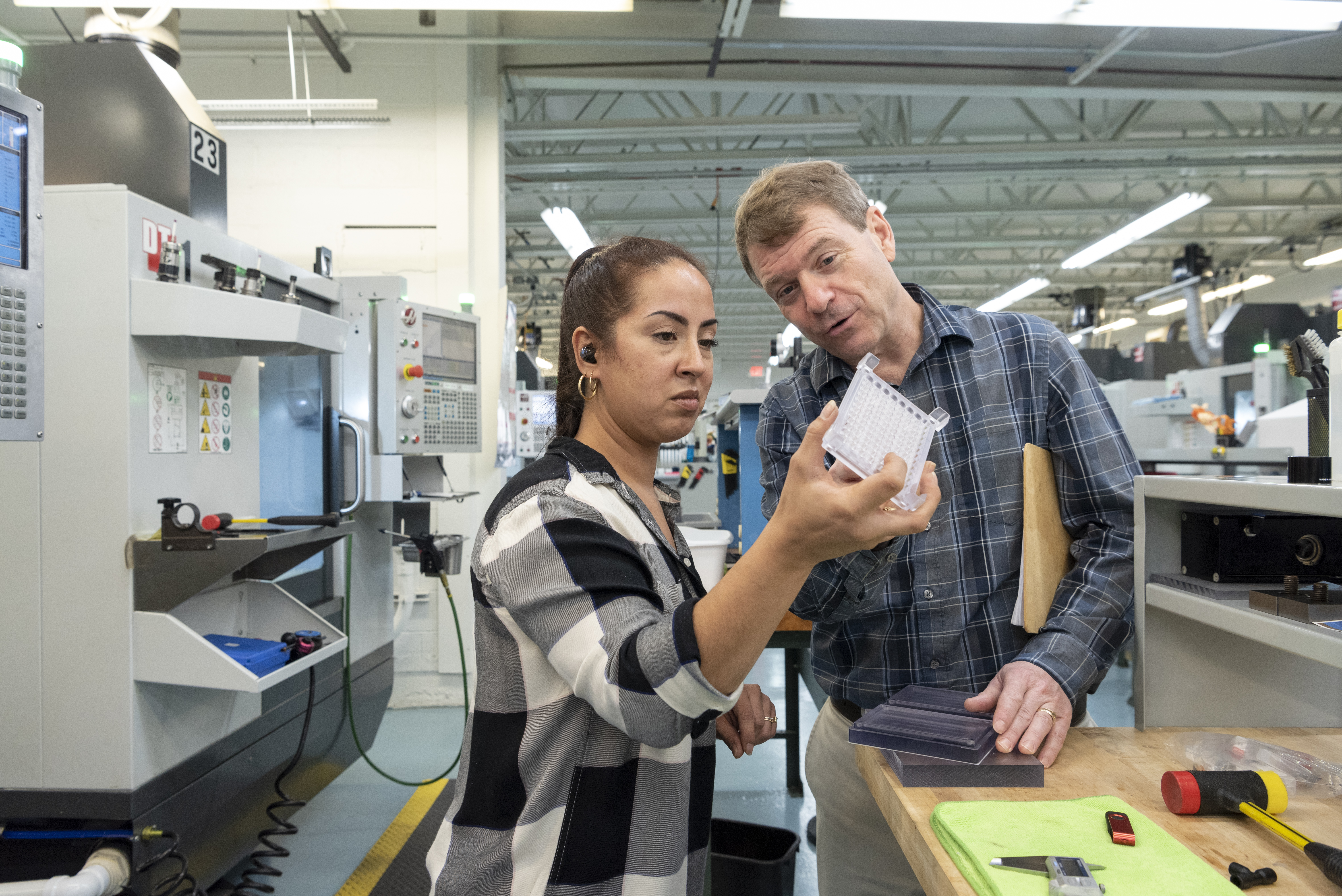 people-inspecting-plastic-manifold.jpg
