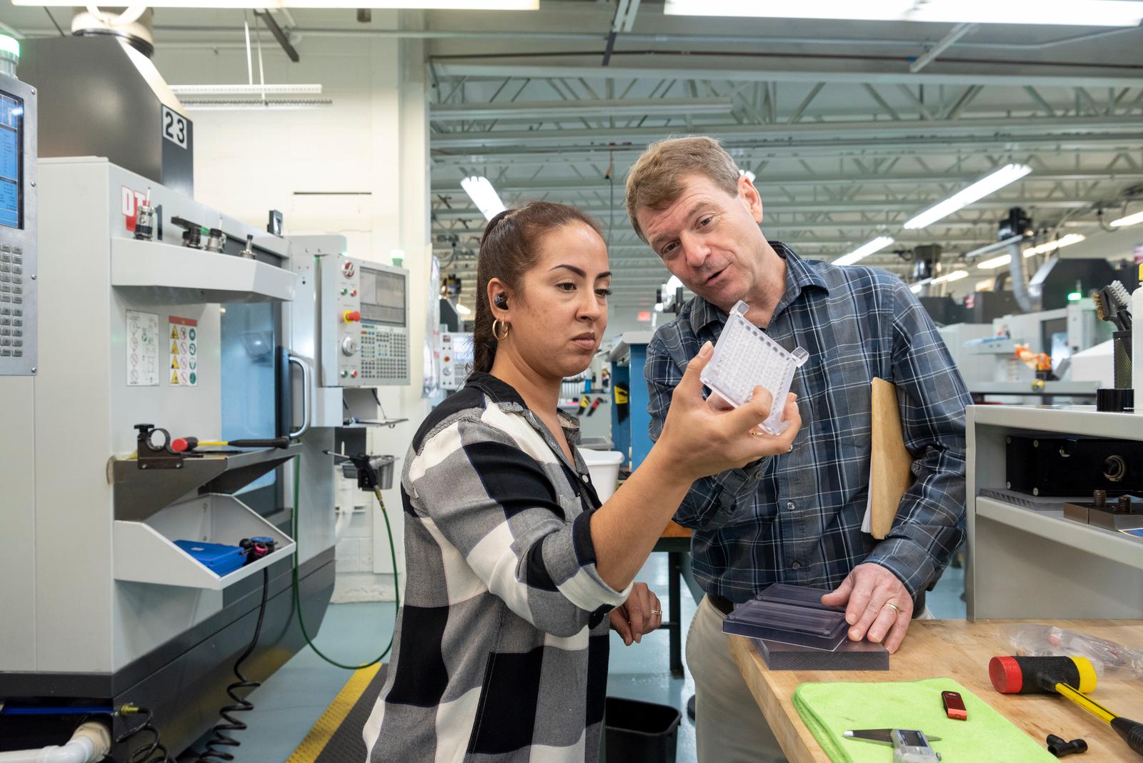 people-inspecting-plastic-manifold.jpg