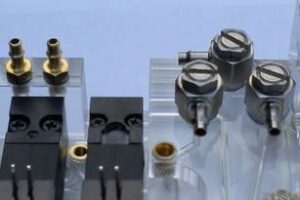 Barb fittings on clear plastic manifold with other fixtures for a full assembly