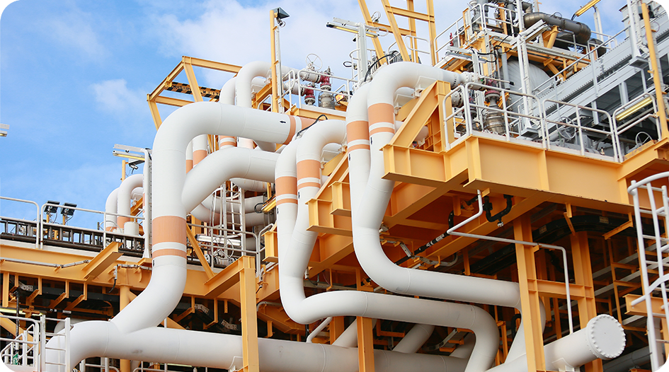 Industrial oil and gas processing facility with piping and process equipment requiring reliable process cooling