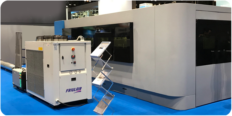 Large industrial laser cutting machine on show floor with Friulair chiller installed for process cooling and continuous duty.