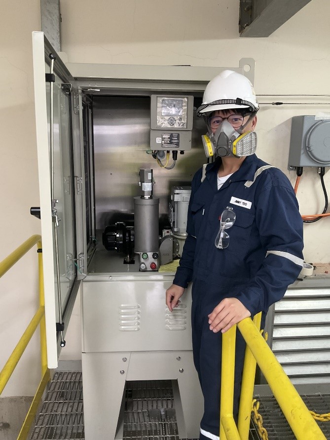 A YZ engineer standing by odorizer, wearing a mask and a hard hat