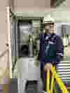 A YZ engineer standing by odorizer, wearing a mask and a hard hat