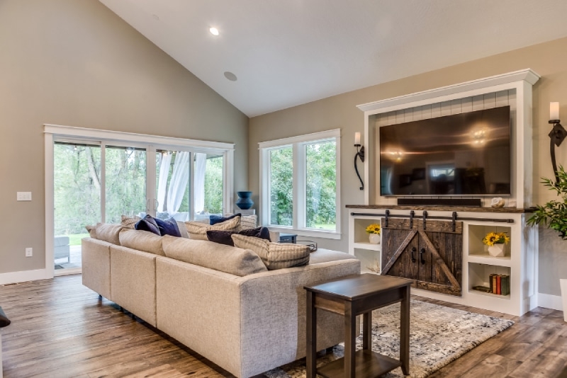 large living room with tv, couch, sliding doors, and a window to the outside