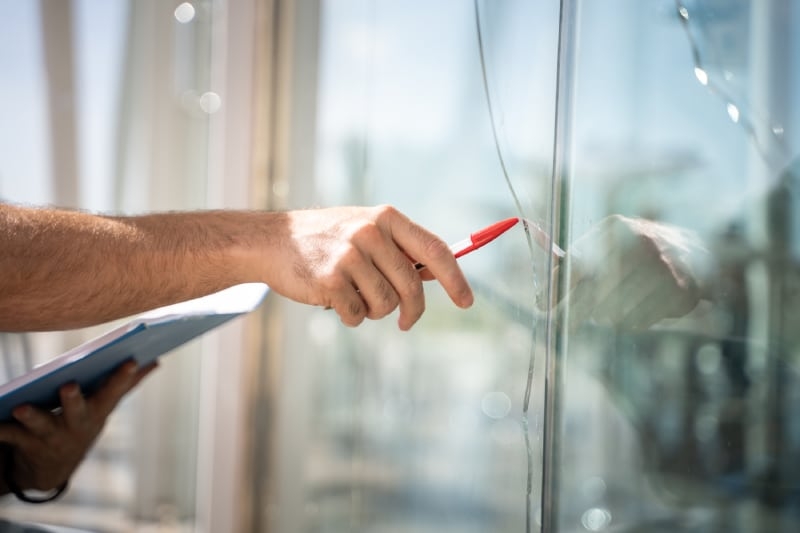 glass broken from a house by an accident, man checking to repair