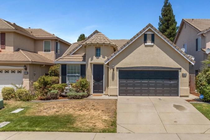 A well-maintained single-family home with a tan exterior, attached garage, and landscaped front yard in Roseville — one of the most desirable Sacramento suburbs.