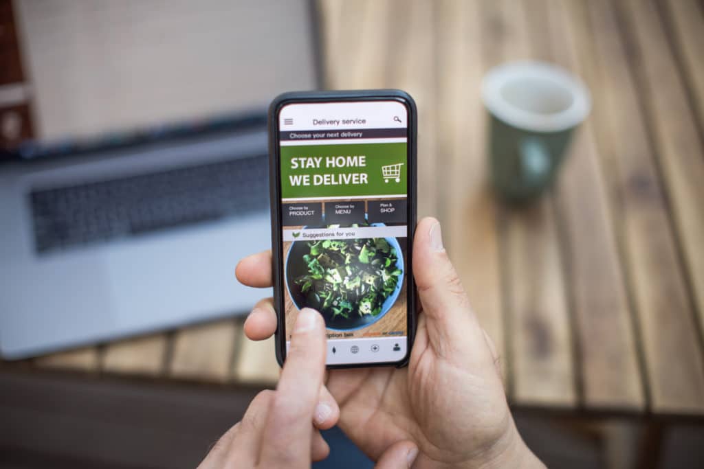 Person holding phone ordering online from ghost kitchens