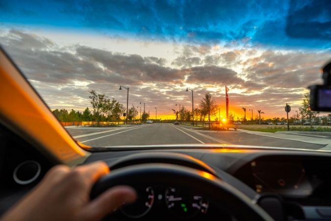 First-person point of view of a driver, living in Fort Myers, Florida, traveling along a well-paved road at sunset.