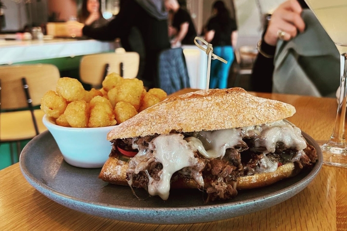 Close-up of a hot beef sandwich with a side of tater tots at The Shelby — a favorite foodie spot for people living in Allentown, PA.