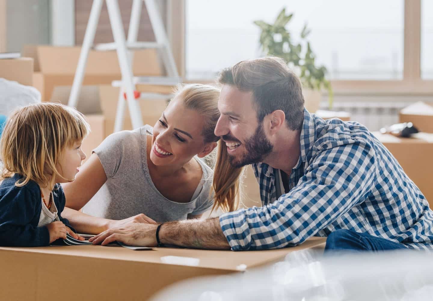 A mother and father smile at their toddler