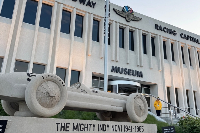 Exterior of the Indianapolis Motor Speedway Museum featuring a vintage race car sculpture and “Racing Capital of the World” signage, highlighting Indiana’s deep racing heritage.