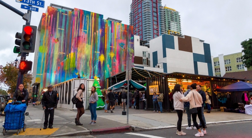 Street-level view of pedestrians and colorful buildings in East Village, one of the best neighborhoods in San Diego.