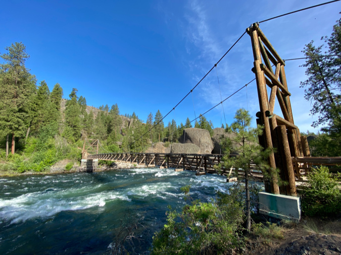 View of a bridge spanning a river at Riverfront State Park in Spokane, Washington, under a clear blue sky.