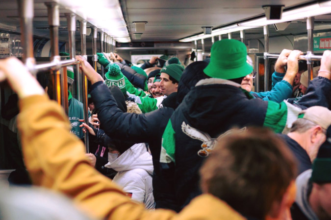 Locals living in Philadelphia ride the subway after a Philadelphia Eagles game.