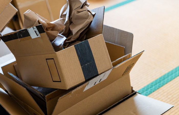 A sloppy stack of delivery boxes and packing paper await new life as recycled moving boxes.