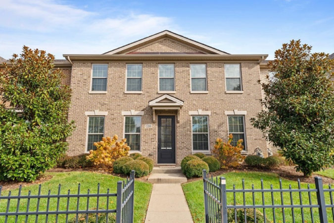 An upscale, Colonial-style townhome in Beaumont — one of the best neighborhoods in Lexington, KY — featuring a brick exterior, nine front-facing windows, and a classic pediment.