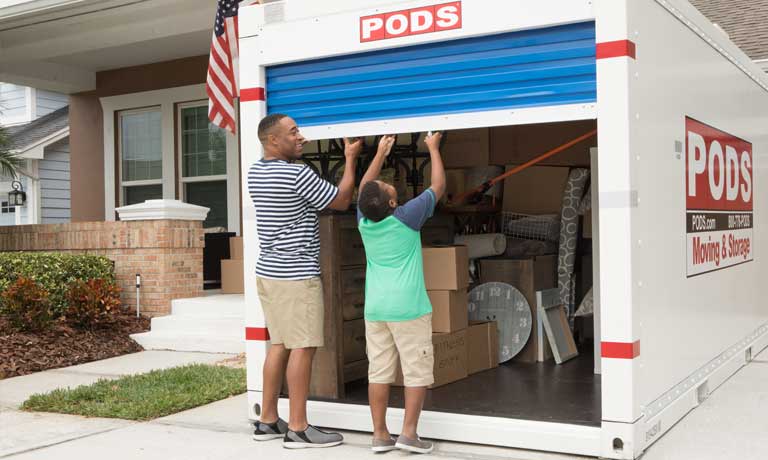 A father and son closing a PODS container as they get ready for their move