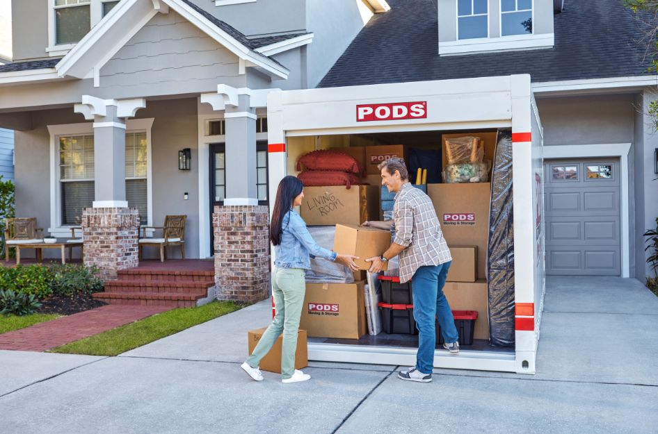 Couple loading a PODS portable storage container outside their home