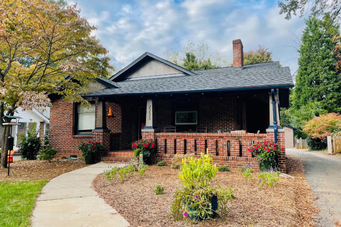 A Craftsman bungalow in Ardmore — one of the best Winston-Salem neighborhoods — featuring a red brick exterior and covered porch.