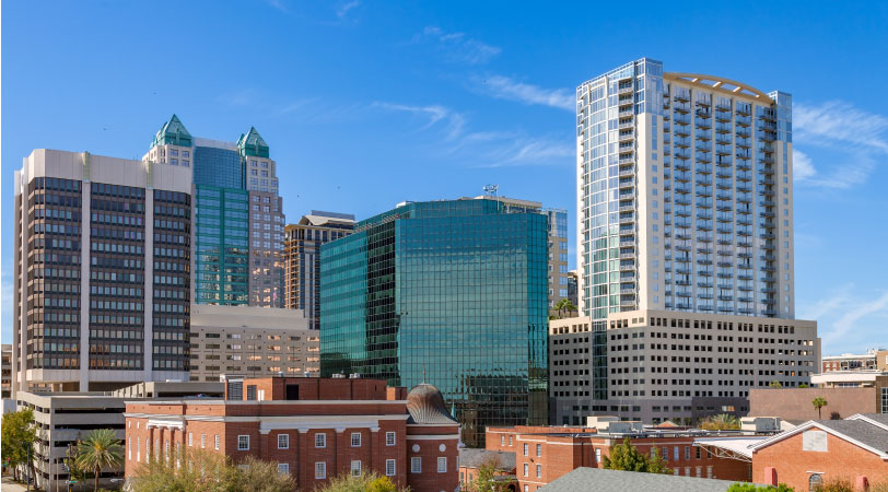 Tall city buildings are shining in the midday sun in the Central Business District, one of the best neighborhoods in Orlando