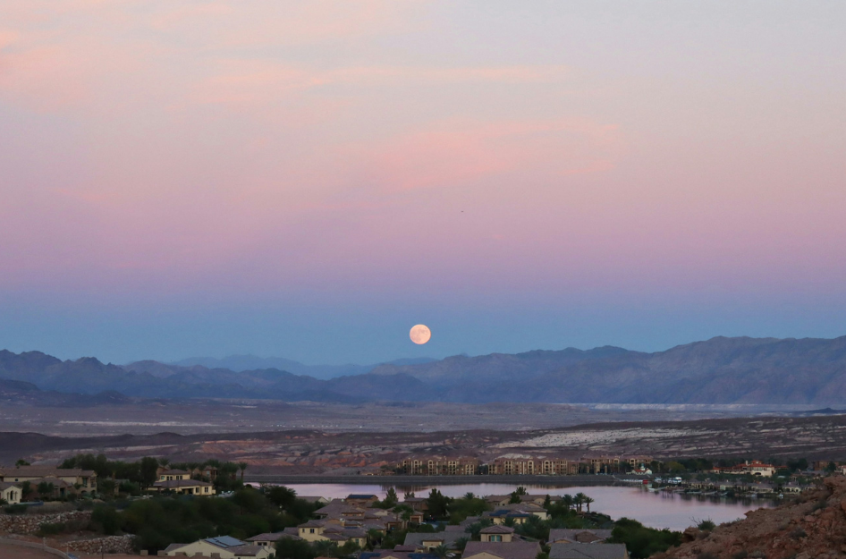 A full moon in a pink and purple sky sitting over one of the best neighborhoods in Henderson, NV.