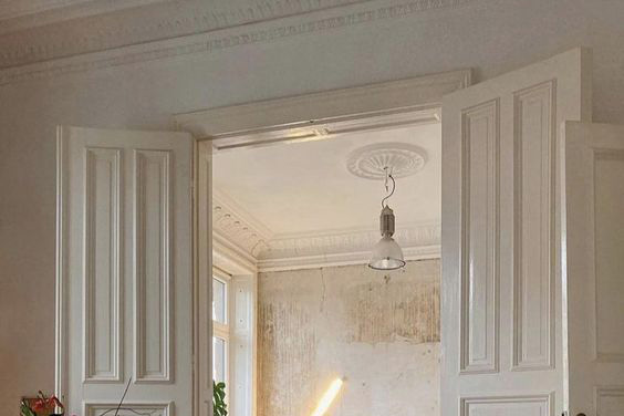 A white room with a door frame that has crown molding. 