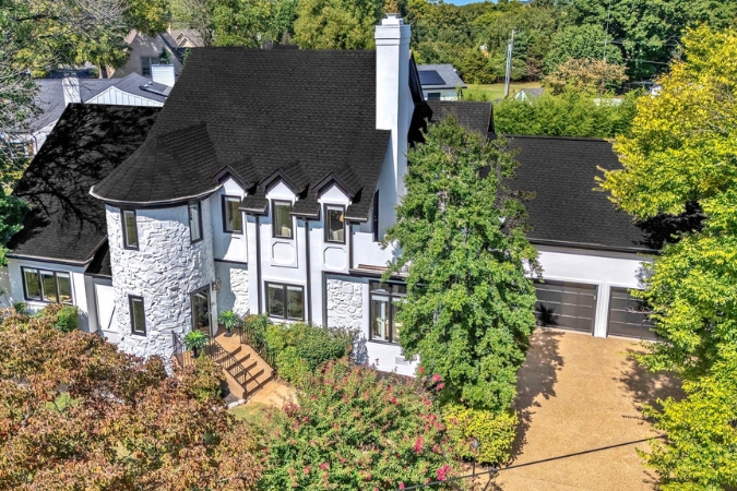 Two-story modern white and black home in downtown Franklin, Tennessee, surrounded by lush trees in an upscale neighborhood, ideal for those moving to Franklin, TN.