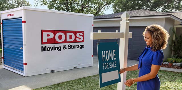 PODS Container in driveway next to home for sale sign