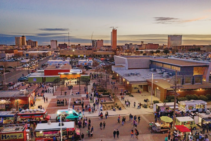 Aerial view of the downtown district in Lubbock, Texas, featuring city streets teeming with pedestrians and food trucks.