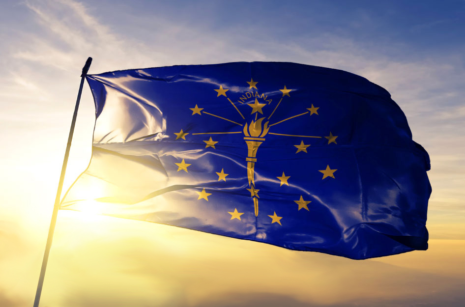 The Indiana state flag, blowing in the wind at the top of a flagpole.