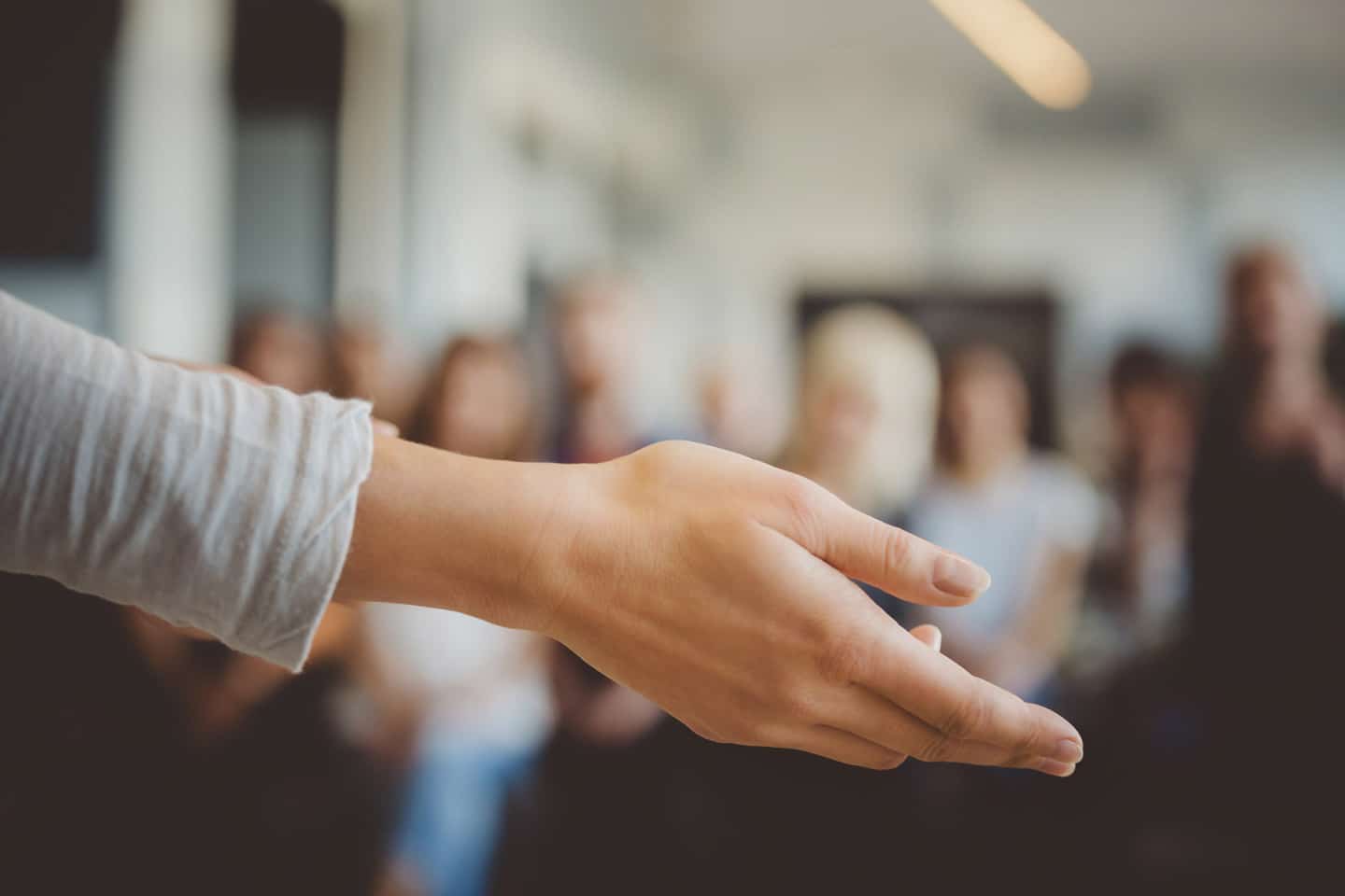 A the hand of a female teacher instructing a group of students