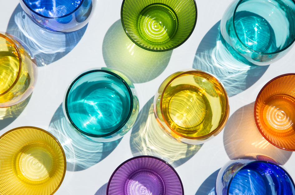 Various styles and colors of drinking glasses seen from above.