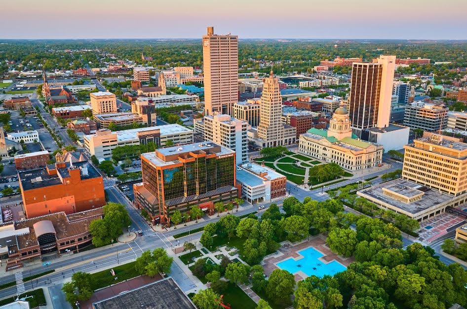 Aerial view of downtown Fort Wayne, Indiana, highlighting tree-lined streets and affordable neighborhoods that make it one of the best places to buy a house.