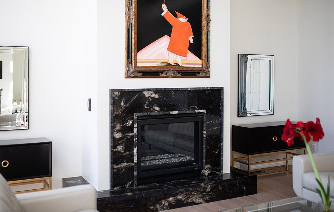 A modern family room with a black marble fireplace