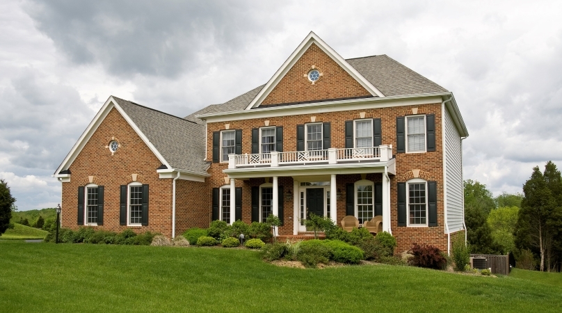 A typical brick home in the SouthPark area of Charlotte, NC. The home has a stately balcony above the front porch and showcases the popular “5, 4, and a door” traditional style.