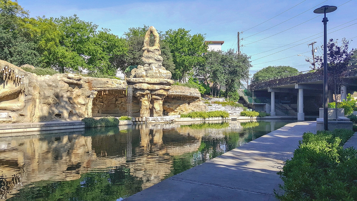 A stone structure by a river leading to the Tobin Hill neighborhood in San Antonio
