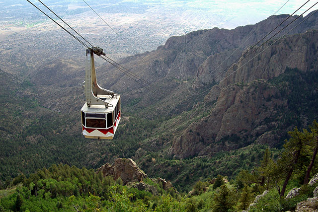 Aerial shot of a gondola going through a valley in Albuquerque